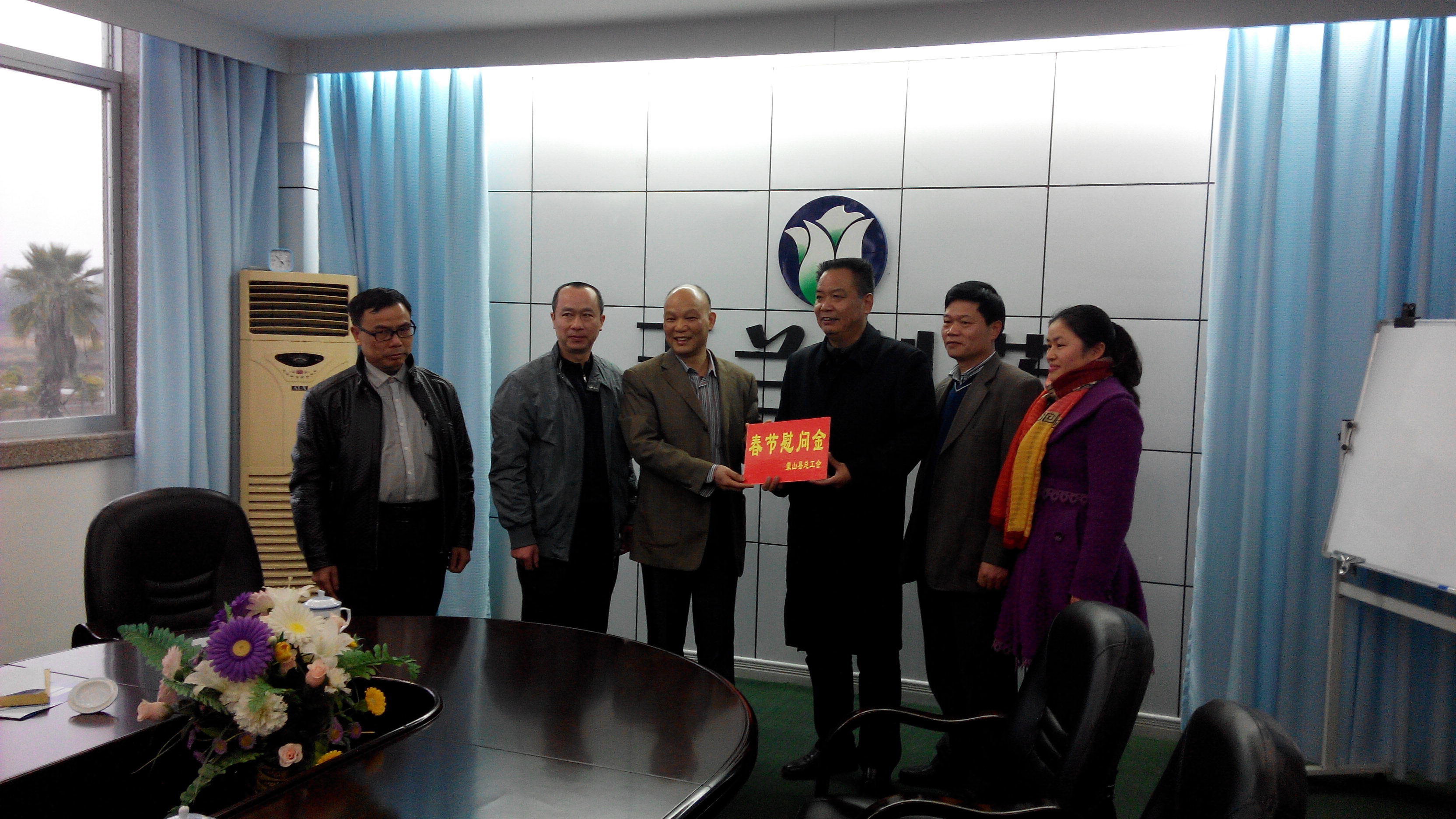 1月28日，梧州市總工會(huì)副主席謝海益帶隊(duì)到蒙山開展春節(jié)前慰問(wèn)活動(dòng)。圖為市總工會(huì)謝副主席給玉蘭制藥公司送上春節(jié)慰問(wèn)金。--