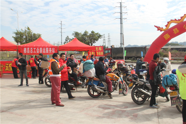 圖為藤縣總工會(huì)在省道304線藤縣陶瓷工業(yè)園區(qū)商業(yè)街小廣場(chǎng)設(shè)立藤縣總工會(huì)為農(nóng)民工平安返鄉(xiāng)“暖流行動(dòng)”服務(wù)站，積極為騎摩托車(chē)